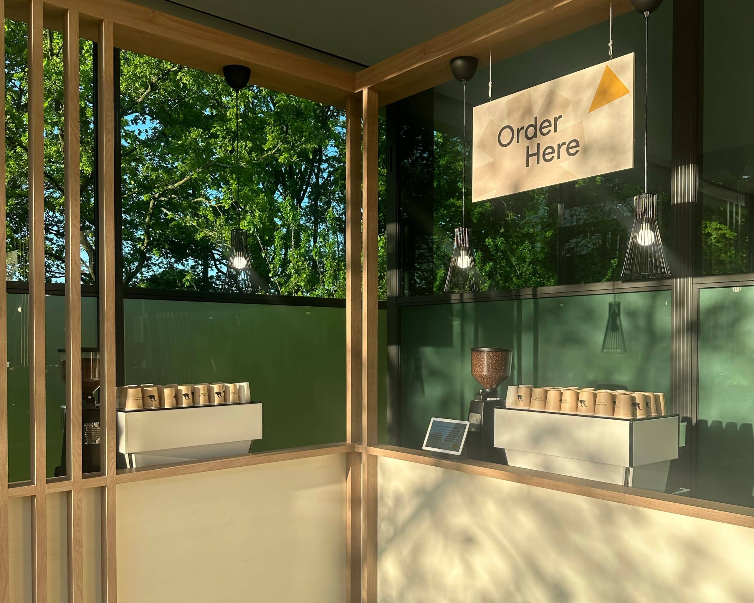 Two espresso machines on a wooden Google branded bar in the sunlight.