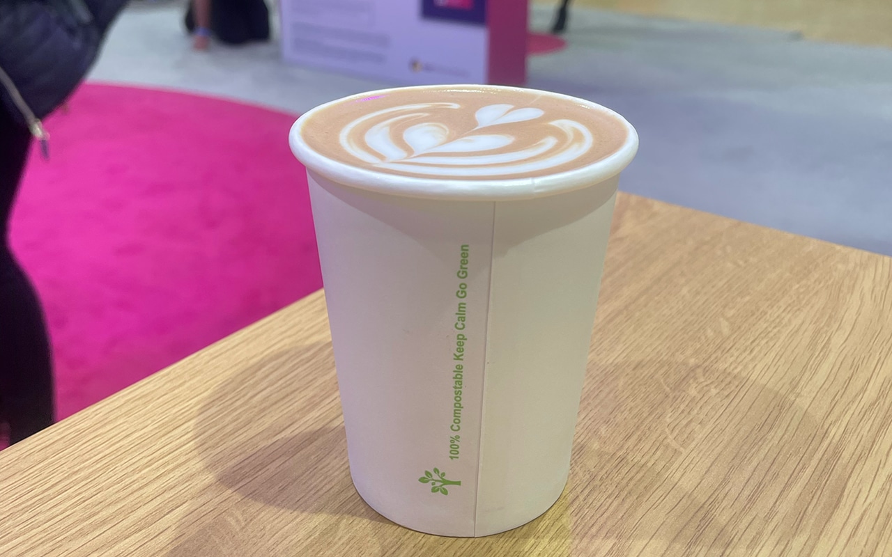An image of a cup of coffee at a conference sat on top of a bar.
