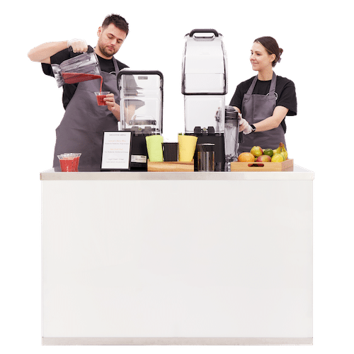 two baristas behind a mobile smoothie bar for events